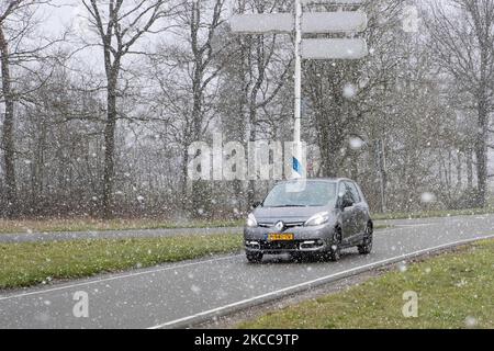 Auto auf der Straße während des Schnees. Der Schneefall in den Niederlanden macht das erste „Weiße Ostern“ nach langer Zeit mit einem deutlichen Temperaturabfall und erreicht nach Angaben der niederländischen Wetterbehörde KNMI den Gefrierpunkt, was den Ostermontag zu einem der kältesten Tage aller Zeiten mit niedrigen Temperaturen macht. Zusätzlich zu Schnee, Hagel und hoher Geschwindigkeit kam es zu starkem eisgekühlten Wind. Die KNMI hat für Montag Abend eine gelbe Wetterwarnung herausgegeben, die besagt, dass es starke Winde und rutschige Bedingungen auf den Straßen geben wird. Der Blast des kalten Wetters mit dem unheimlichen Wetter erschien nach historischen Tagen von Stockfoto