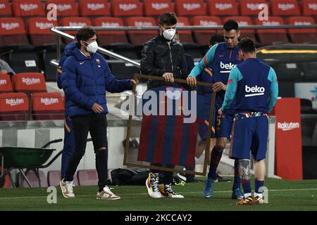 (L-R) die Kapitäne Sergi Roberto, Gerard Pique und Sergio Busquets liefern ein signiertes Trikot aus, um an die Aufzeichnung der Spielerspiele mit Barcelona durch Leo Messi vor dem Spiel der La Liga Santander zwischen dem FC Barcelona und Real Valladolid CF im Camp Nou am 5. April 2021 in Barcelona, Spanien, zu erinnern. Sportstadien in ganz Spanien unterliegen aufgrund der Coronavirus-Pandemie weiterhin strengen Beschränkungen, da staatliche Gesetze zur sozialen Distanzierung Fans innerhalb von Veranstaltungsorten verbieten, was dazu führt, dass Spiele hinter verschlossenen Türen gespielt werden. (Foto von Jose Breton/Pics Action/NurPhoto) Stockfoto