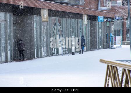 Menschen vor den Geschäften im Schnee. Die Niederlande wachen nach einem intensiven morgendlichen Schneefall, einem bizarren Ereignis im April, mit Schnee bedeckt auf. Der zweite Tag mit niedrigen Temperaturen und Schneefall in den Niederlanden nach dem „Weißen Ostermontag“ mit einem deutlichen Temperaturabfall, der nach Angaben der niederländischen Meteorologischen Agentur KNMI den Gefrierpunkt erreicht hat und den Ostermontag zu einem der kältesten Tage aller Zeiten mit niedrigen Temperaturen macht. Zusätzlich zu Schnee, Hagel und hoher Geschwindigkeit kam es zu starkem eisgekühlten Wind. Die KNMI hat eine gelbe Wetterwarnung für Montag Abend herausgegeben, die besagt, dass es stark sein wird Stockfoto