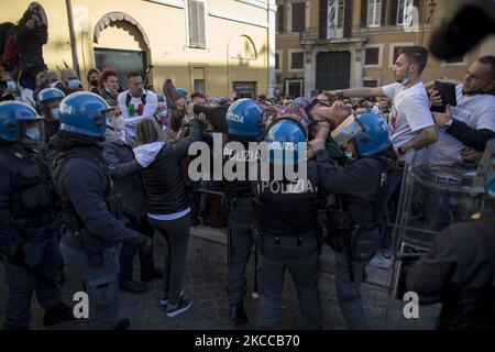 Anti-Aufruhr-Polizisten konfrontieren Demonstranten während einer Demonstration von Restaurantbesitzern, Unternehmern und Kleinunternehmern am 6. April 2021 vor dem parlament auf der Piazza Montecitorio in Rom, um die Wiederaufnahme von Aktivitäten zu fordern, die aufgrund der Covid-19-Beschränkungen eingestellt werden müssen (Foto: Christian Minelli/NurPhoto) Stockfoto