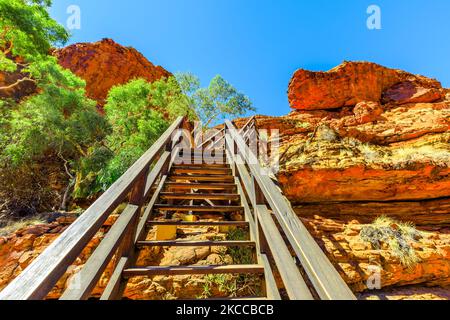 Holztreppe entlang des Kings Canyon Rim mit Fußgängerbrücke über den Garden of Eden im Watarrka National Park, Australien. Stufen führen zum Gipfel des Canyons mit Stockfoto