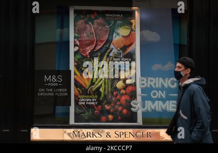 Eine Person geht an Marks und Spencers Fenster vorbei, mit einem Aufkleber mit der Aufschrift „Bring On Summer“ - auf der Grafton Street im Stadtzentrum von Dublin, während der Covid-19-Sperre auf Level 5. Am Mittwoch, den 7. April 2021, in Dublin, Irland. (Foto von Artur Widak/NurPhoto) Stockfoto