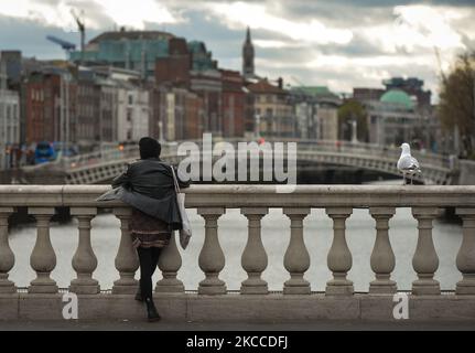 Eine Frau schaut von der O'Connell Bridge auf dem Fluss Liffey in Dublin während der COVID-19-Sperre der Stufe 5 auf. Am Donnerstag, den 8. April 2021, in Dublin, Irland. (Foto von Artur Widak/NurPhoto) Stockfoto