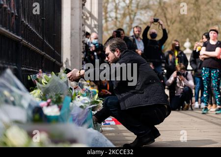 Der Mann legt vor dem Buckingham Palace einen Blumenstrauß nieder, nachdem bekannt gegeben wurde, dass der britische Prinz Philip, Ehemann von Queen Elizabeth, im Alter von 99 Jahren gestorben ist, London, Großbritannien, 9. April 2021. Der Ehemann von Königin Elizabeth II., Prinz Philip, der vor kurzem mehr als einen Monat im Krankenhaus verbrachte und sich einer Herzprozedur unterzog, starb am 9. April 2021, teilte Buckingham Palace mit. (Foto von Maciek Musialek/NurPhoto) Stockfoto