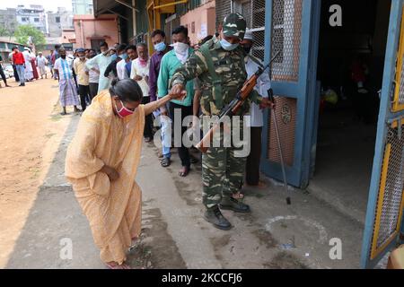 Eine ältere Wählerin wird von Einem paramilitärischen Personal unterstützt, nachdem sie während der Phase 4 der Parlamentswahlen in Westbengalen im Bezirk Howrah bei Kalkutta am 10. April 2021 ihre Stimme in einem Wahllokal abgegeben hat. (Foto von Debajyoti Chakraborty/NurPhoto) Stockfoto