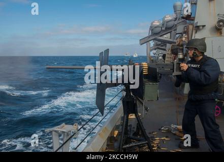 Personnel Specialist feuert ein M2HB 50-Kaliber-Maschinengewehr an Bord der USS the Sullivans. Stockfoto