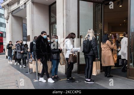 LONDON, GROSSBRITANNIEN - 12. APRIL 2021: Käufer betreten den H&M-Laden in der Oxford Street, nachdem die Geschäfte am 12. April 2021 in London, England, nach mehr als drei Monaten Schließung durch Coronavirus ihre Räumlichkeiten für Kunden geöffnet haben. Ab heute geht die nächste Stufe der Aufhebung von Sperrbeschränkungen voran, indem Pubs und Restaurants erlaubt sind, Speisen und Getränke im Freien zu servieren, und die Eröffnung von nicht notwendigen Geschäften, Friseuren, Schönheitssalons und Fitnessstudios in England. (Foto von Wiktor Szymanowicz/NurPhoto) Stockfoto