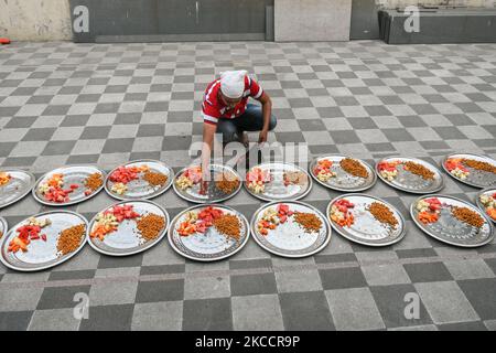 Ein Mann verteilt verschiedene Früchte und Lebensmittel, um das Iftar-Fasten für den Tag während der Ramadan-Beobachtung in einer Moschee in Kalkutta, Indien, am 15. April 2021 zu brechen. (Foto von Debarchan Chatterjee/NurPhoto) Stockfoto