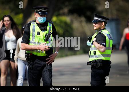 Polizeibeamte werden bei sonnigem Wetter am 16. April 2021 im Kelvingrove Park in Glasgow, Schottland, auf Patrouille gesehen. Die Einschränkungen von Covid 19 beginnen sich ab heute zu lockern, sodass sich sechs Personen aus bis zu sechs Haushalten im Freien treffen können und die Reisebeschränkungen innerhalb des Bezirks verringert werden. (Foto von Ewan Bootman/NurPhoto) Stockfoto