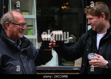 Zwei Männer genießen Guinness-Bier zum Mitnehmen in den Plastikbechern von Hop House Lager in der Straße im Stadtzentrum von Dublin während der COVID-19-Sperre. Am Freitag, den 16. April 2021, in Dublin, Irland. (Foto von Artur Widak/NurPhoto) Stockfoto