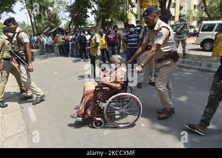 Eine ältere Wählerin wird von einem paramilitärischen Personal unterstützt, nachdem sie ihre Stimme in einem Wahllokal während der fünften Phase der Wahlen zur Versammlung in Westbengalen in Kalkutta, Indien, am 17. April 2021 abgegeben hat. Laut einem indischen Medienbericht hat die Wahlkommission beschlossen, Kundgebungen, öffentliche Treffen und Straßenveranstaltungen in West-Bengalen von 7 bis 10 Uhr aufgrund der Covid-19-Spitze in Indien zu verbieten. (Foto von Indranil Aditya/NurPhoto) Stockfoto