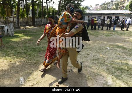 Eine ältere Wählerin wird von einem paramilitärischen Personal unterstützt, nachdem sie ihre Stimme in einem Wahllokal während der fünften Phase der Wahlen zur Versammlung in Westbengalen in Kalkutta, Indien, am 17. April 2021 abgegeben hat. Laut einem indischen Medienbericht hat die Wahlkommission beschlossen, Kundgebungen, öffentliche Treffen und Straßenveranstaltungen in West-Bengalen von 7 bis 10 Uhr aufgrund der Covid-19-Spitze in Indien zu verbieten. (Foto von Indranil Aditya/NurPhoto) Stockfoto