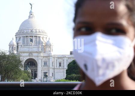 Eine Frau mit einer Maske steht vor der berühmten historischen Victoria Memorial Hall, die am 19,2021. April aufgrund der Pandemie des Covid-19 in Kalkutta, Indien, geschlossen wurde. Da Bengaluru am Wochenende insgesamt 24.197 Fälle meldete, stiegen die aktiven Fälle in der Hauptstadt Karnataka am Sonntag (97.897) auf fast einen See. Währenddessen erlagen am Samstag und Sonntag 103 weitere Menschen dem gleichen.der Bundesstaat Westbengalen verzeichnete mit 8.419 neuen COVID-19-Fällen den höchsten Tageshöchststand. Einem Bericht zufolge haben mindestens 28 neue Todesfälle die Zahl der Todesopfer in Westbengalen auf 10.568 angestoßen. (Foto von Debajyoti Chakrabo Stockfoto