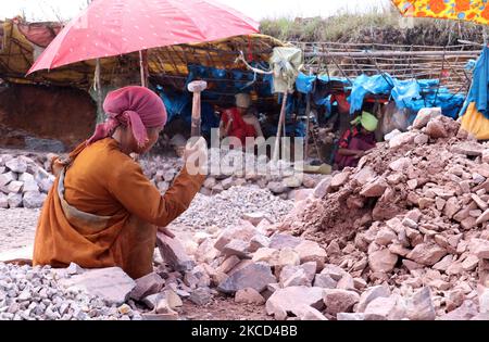 Khasi-Frauen brechen am 20. April 2021 in einem Dorf in Meghalaya, Indien, Steine in verschiedene Größen mit Hammer. Frauen, die Steinbrecher machen, verdienen ihren Lebensunterhalt, indem sie in den Schichtensteinbrüchen arbeiten, und die Männer helfen ihnen, indem sie die großen Steine vom Hügel herunterbringen. (Foto von David Talukdar/NurPhoto) Stockfoto