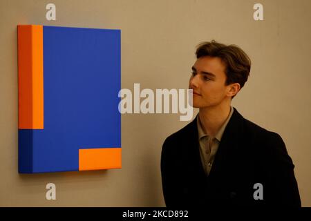 Ein Mitarbeiter posiert neben „Untitled“ der kubanisch-amerikanischen Künstlerin Carmen Herrera, die auf GBP150.000 bis 200.000 geschätzt wird, während einer Pressevorschau für den bevorstehenden Verkauf zeitgenössischer Kunst im Bonhams Auktionshaus in London, England, am 22. April 2021. Der Verkauf findet am 27. April statt. (Foto von David Cliff/NurPhoto) Stockfoto