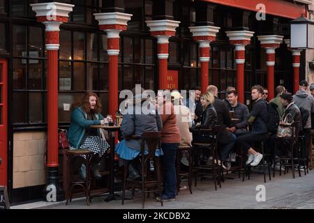 LONDON, VEREINIGTES KÖNIGREICH - 24. APRIL 2021: Am zweiten Wochenende nach der Lockerung der Einschränkungen des Coronavirus am 24. April 2021 in London, England, genießen die Menschen Getränke und treffen sich mit Freunden in Soho. (Foto von Wiktor Szymanowicz/NurPhoto) Stockfoto