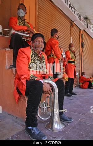 Heiratskapelle, sitzen außerhalb der geschlossenen Geschäfte während der Hochzeitssaison in Choti Chaupar, in Jaipur, Rajasthan, Indien, am 26. April, 2021. Blaskapellen-Anbieter und Artisten sind wegen der COVID-19-Pandemie in Not Da die Behörden neue Richtlinien vorlegen, spielen nur wenige Artisten Band in Hochzeiten. (Foto von Vishal Bhatnagar/NurPhoto) (Foto von Vishal Bhatnagar/NurPhoto) Stockfoto