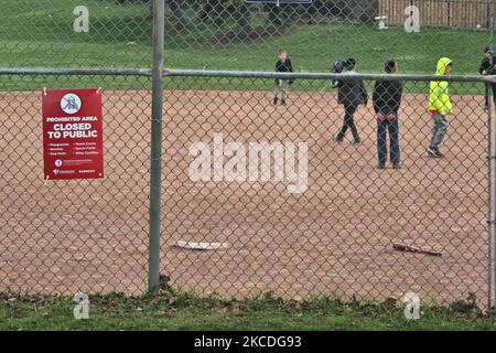 Kinder spielen auf einem Park-Baseballdiamanten, der geschlossen wurde, um die Ausbreitung des neuartigen Coronavirus (COVID-19) in Vaughan, Ontario, Kanada, am 26. April 2021 zu verhindern. (Foto von Creative Touch Imaging Ltd./NurPhoto) Stockfoto