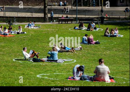 Die Menschen sitzen in Kreisen, die auf das Gras gemalt sind, während sie die Sonne im Park genießen, während der Feier zum Königstag während der Corona-Pandemie am 27. 2021. April in Nijmegen, Niederlande, Niederlande. (Foto von Romy Arroyo Fernandez/NurPhoto) Stockfoto