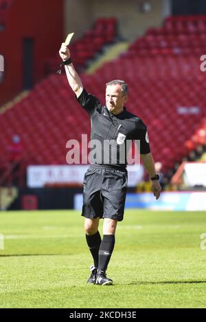 Der Schiedsrichter Keith Stroud zeigt einem Peterborough-Spieler während des Spiels der Sky Bet League 1 zwischen Charlton Athletic und Peterborough am 24.. April 2021 im The Valley, London, England, eine gelbe Karte. (Foto von Ivan Yordanov/MI News/NurPhoto) Stockfoto