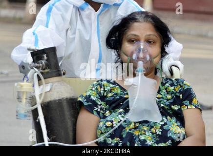 Ein Covid-19-Patient auf einem Rollstuhl geht am 27. April 2021 zu einem medizinischen Test in einem staatlichen Krankenhaus in Kalkutta, Indien. Die Weltgesundheitsorganisation (WHO) sagte am Dienstag, dass sie ihre Bemühungen um Hilfe für Indien verstärken würde, da die Krankenhäuser dort mit einem enormen Anstieg der Coronavirus-Fälle zu kämpfen hatten, einschließlich der Einbringung von Sauerstoff und anderen lebenswichtigen Hilfsgütern, so ein indischer Medienbericht. (Foto von Indranil Aditya/NurPhoto) Stockfoto