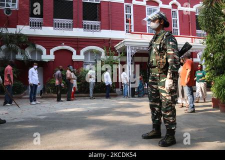 Ein paramilitärisches Frauenpersonal steht und die Wähler stehen in einer Schlange, um ihre Stimme in einem Wahllokal während der Phase der Wahlen zur Versammlung in Westbengalen am 29. April 2021 in Kalkutta, Indien, 8. abzugeben. Die Phase der Wahlen zur Westbengalischen Versammlung 8. 2021 steht vor der Pandemie des Covid-19 Coronavirus. (Foto von Debajyoti Chakraborty/NurPhoto) Stockfoto
