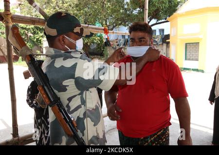 Ein paramilitärisches Personal, das die chirurgische Gesichtsmaske auf den Wählern anstachelt, steht vor dem Betreten eines Wahllokale, um während der Phase der Wahlen zur Versammlung in Westbengalen am 29. April 2021 in Kalkutta, Indien, im Jahr 8. seine Stimme abzugeben. Die Phase der Wahlen zur Westbengalischen Versammlung 8. 2021 steht vor der Pandemie des Covid-19 Coronavirus. (Foto von Debajyoti Chakraborty/NurPhoto) Stockfoto