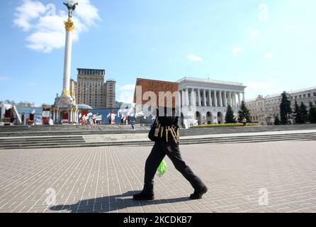 Ein Mann, der eine Schutzmaske und Bänder mit Meerrettich trägt, geht am 29. April 2021 auf dem Unabhängigkeitsplatz im Zentrum von Kiew, Ukraine, mit einem Plakat mit der Aufschrift „Es gibt eine Waffe gegen COVID-19“ zu einer Meerrettich-Behandlung. Ab Mai 1 würden strikte Quarantänebeschränkungen in der ukrainischen Hauptstadt gelockert, da die Zahl der neuen COVID-19-Fälle langsam sinkt, der öffentliche Nahverkehr und die U-Bahn wie gewohnt in Übereinstimmung mit den Normen und Regeln zur Bekämpfung der Epidemie, wie lokale Medien berichteten, zu arbeiten beginnen werden. 387 Menschen starben an Komplikationen der COVID-19-Coronavirus-Krankheit im La Stockfoto