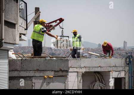 Am 4. Mai 2021 begannen die Bewohner von Istanbul, Türkei, die Arbeitswoche unter strengen Covid-19-Ausgangssperren, die die soziale Distanzierung fördern und viele Arbeitnehmer zu Hause halten sollten, um einen Anstieg der Coronavirus-Fälle zu reduzieren. Darüber bauen Bauarbeiter ein Bürogebäude im Stadtteil Beyoglu der Stadt. (Foto von Diego Cupolo/NurPhoto) Stockfoto