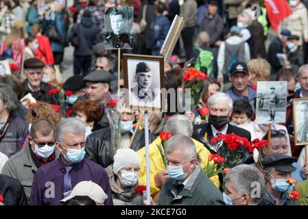 Während der Feier des Siegesfestes am 9. Mai 2021, bei der der Ausbruch des Covid-19-Coronavirus in Kiew, Ukraine, stattfand, tragen Menschen Blumen zum Denkmal des ewigen Ruhms auf dem Grab des unbekannten Soldaten. Die Ukrainer gedenken des 76.. Jahrestages des Sieges über Nazi-Deutschland im Zweiten Weltkrieg (Foto von STR/NurPhoto) Stockfoto