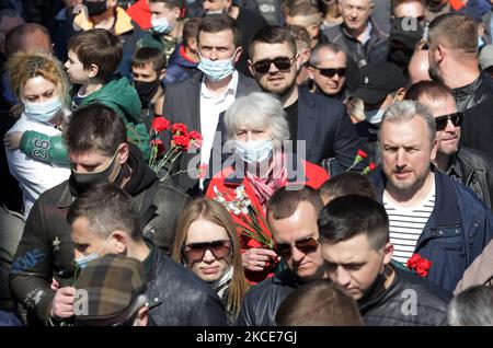 Während der Feier des Siegesfestes am 9. Mai 2021, bei der der Ausbruch des Covid-19-Coronavirus in Kiew, Ukraine, stattfand, tragen Menschen Blumen zum Denkmal des ewigen Ruhms auf dem Grab des unbekannten Soldaten. Die Ukrainer gedenken des 76.. Jahrestages des Sieges über Nazi-Deutschland im Zweiten Weltkrieg (Foto von STR/NurPhoto) Stockfoto