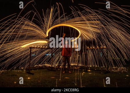 Ein Malaysischer schwingt ein selbstgemachtes Wunderkerzen-Feuerwerk vor den Eid al-Fitr-Feierlichkeiten, dem religiösen Fest, das das Ende des Fastenmonats Ramadan markiert, inmitten der anhaltenden Coronavirus-Pandemie COVID-19 in Kuala Lumpur am 9. Mai 2021. (Foto von Mohd Firdaus/NurPhoto) Stockfoto