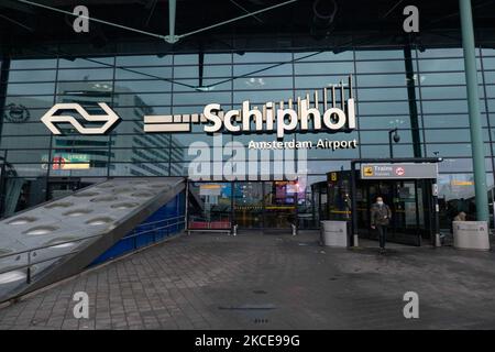 Eingang zum Flughafen Schiphol mit Menschen, die Gesichtsmaske tragen. Internationaler Flughafen Amsterdam Schiphol während der Pandemie Covid-19. Die Anzahl der Passagiere und die Crew tragen Schutzausrüstung wie die obligatorischen Gesichtsmasken und Handschuhe, um die Ausbreitung des Coronavirus zu vermeiden. Die Zahl der Passagiere im Weltflug sank aufgrund der Reisebeschränkungen, Sicherheitsmaßnahmen wie Sperren, Quarantäne, PCR und Schnelltests vor den Flügen während der Ära der Coronavirus-Pandemie Covid-19, die die Luft- und Reisebranche schwer getroffen hatte. Amster Stockfoto