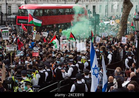 LONDON, VEREINIGTES KÖNIGREICH – 11. MAI 2021: Polizeibeamte eskortieren eine kleine Gruppe pro-israelischer Gegendemonstranten während eines pro-palästinensischen Protestes vor der Downing Street gegen eine Eskalation der Gewalt, die durch die geplanten Räumungen palästinensischer Familien durch jüdische Siedler im Sheikh Jarrah Bezirk in Ost-Jerusalem am 11. Mai 2021 in London, England, ausgelöst wurde. Die Spannungen zwischen Israel und Palästina haben in den letzten Tagen zugenommen, als Hunderte von Palästinensern bei Zusammenstößen mit Sicherheitskräften in der Altstadt und vor der al-Aqsa-Moschee in Jerusalem verletzt wurden, gefolgt von einem Austausch Stockfoto