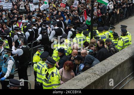 LONDON, VEREINIGTES KÖNIGREICH – 11. MAI 2021: Polizeibeamte eskortieren eine kleine Gruppe pro-israelischer Gegendemonstranten während eines pro-palästinensischen Protestes vor der Downing Street gegen eine Eskalation der Gewalt, die durch die geplanten Räumungen palästinensischer Familien durch jüdische Siedler im Sheikh Jarrah Bezirk in Ost-Jerusalem am 11. Mai 2021 in London, England, ausgelöst wurde. Die Spannungen zwischen Israel und Palästina haben in den letzten Tagen zugenommen, als Hunderte von Palästinensern bei Zusammenstößen mit Sicherheitskräften in der Altstadt und vor der al-Aqsa-Moschee in Jerusalem verletzt wurden, gefolgt von einem Austausch Stockfoto