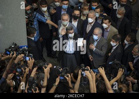 Der ehemalige Präsident Mahmoud Ahmadinedschad (C) zeigt sich mit Gesten, als er seine Identifikation vorhält, während er am 12. Mai 2021 im Gebäude des iranischen Innenministeriums als Kandidat für die Präsidentschaftswahlen vom 18. Juni in Zentral-Teheran kandidierte. (Foto von Morteza Nikoubazl/NurPhoto) Stockfoto