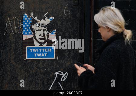 Eine Frau kommt an einem Plakat vorbei, auf dem das Bild des ehemaligen US-Präsidenten Donald Trump und die Worte „Twitter twat“ im Stadtzentrum von Dublin zu sehen sind. Am Mittwoch, den 12. Mai 2021, in Dublin, Irland. (Foto von Artur Widak/NurPhoto) Stockfoto