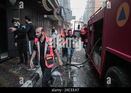 Sicherheitsbeamte inspizieren beschädigte Gebäude in Gaza-Stadt nach einem israelischen Luftangriff am 12. Mai 2021 im Gazastreifen (Foto: Momen Faiz/NurPhoto) Stockfoto