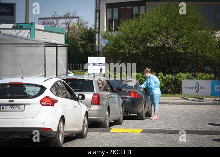 Eine Frau registriert Menschen und nimmt ihre Temperaturen am 12. Mai 2021 an der ersten Drive-Thru-Impfstelle COVID-19 in Warschau, Polen, auf. Die erste Durchlaufimpfstelle in Warschau wird derzeit rund 120 Menschen pro Tag behandeln und mindestens für die nächsten sechs Monate dort bleiben. An diesem Samstag wird der nächste Schritt zur Lockerung der COVID-19-Beschränkungen stattfinden, in dem Bars und Restaurants Freiflächen nutzen dürfen. Polen hat 28 Prozent seiner Bevölkerung geimpft, knapp unter dem EU-Durchschnitt von 29 Prozent. (Foto von STR/NurPhoto) Stockfoto