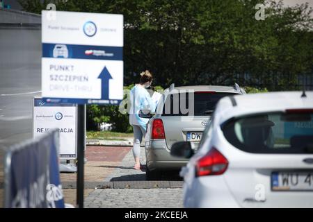 Eine Frau registriert Menschen und nimmt ihre Temperaturen am 12. Mai 2021 an der ersten Drive-Thru-Impfstelle COVID-19 in Warschau, Polen, auf. Die erste Durchlaufimpfstelle in Warschau wird derzeit rund 120 Menschen pro Tag behandeln und mindestens für die nächsten sechs Monate dort bleiben. An diesem Samstag wird der nächste Schritt zur Lockerung der COVID-19-Beschränkungen stattfinden, in dem Bars und Restaurants Freiflächen nutzen dürfen. Polen hat 28 Prozent seiner Bevölkerung geimpft, knapp unter dem EU-Durchschnitt von 29 Prozent. (Foto von STR/NurPhoto) Stockfoto