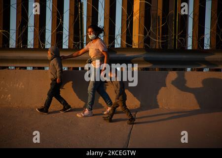 Eine Mutter und ihre beiden Kinder gehen am 11. Mai 2021 nach der Überquerung des Rio Grande, der natürlichen Grenze zwischen Mexiko und den Vereinigten Staaten in Ciudad Juarez, Chihuahua, Mexiko, auf eine Seite der Mauer der Vereinigten Staaten. (Foto von David Peinado/NurPhoto) Stockfoto