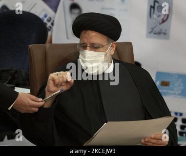 Ebrahim Raisi, konservativer Politiker und Leiter der iranischen Justiz, erhält einen Stift, als er ein Dokument ausfüllt, während er am 15. Mai 2021 im Gebäude des iranischen Innenministeriums als Kandidat für die Präsidentschaftswahlen vom 18. Juni in Zentral-Teheran kandidiert. (Foto von Morteza Nikoubazl/NurPhoto) Stockfoto