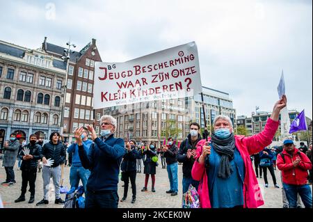 Ein Paar hält ein großes Banner während der Demonstration zur Unterstützung der Opfer des niederländischen Kinderbetreuungsskandals in den Niederlanden, die am 15.. Mai 2021 in Amsterdam, Niederlande, stattfand. (Foto von Romy Arroyo Fernandez/NurPhoto) Stockfoto