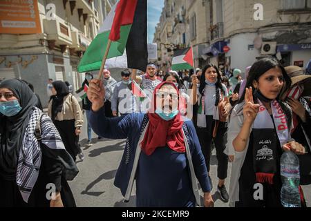 Weibliche Demonstranten schwenken die palästinensische Flagge, während sie Anti-Israel-Parolen während eines marsches rufen, der am 15. Mai 2021 in der tunesischen Hauptstadt Tunis auf der Straße stattfand. Zur Unterstützung des palästinensischen Volkes und zum Protest gegen die israelischen Luftangriffe auf den Gazastreifen und gegen die israelischen Verletzungen in den besetzten Gebieten Palästinas, insbesondere in der palästinensischen Nachbarschaft in Ostjerusalem, Sheikh Jarrah. (Foto von Chedly Ben Ibrahim/NurPhoto) Stockfoto