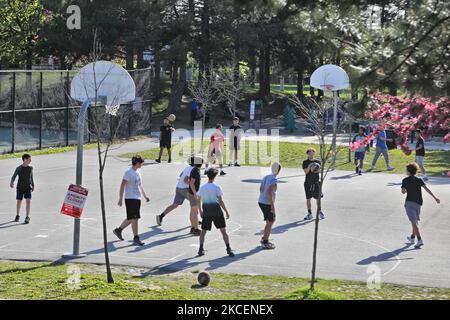 Jugendliche trotzen den Regeln der öffentlichen Gesundheit, während sie sich zusammentrommeln, um auf einem Basketballplatz im Park zu spielen, der von der regierungsweiten Aufenthaltsordnung der Regierung von Ontario geschlossen wurde, um die Ausbreitung des neuartigen Coronavirus (COVID-19) am 14. Mai 2021 in Vaughan, Ontario, Kanada, zu verlangsamen. Der Aufenthalt zu Hause in Ontario wurde vor kurzem um weitere zwei Wochen bis mindestens Juni 02 2021 verlängert, da COVID-19-Fälle in der gesamten Provinz ansteigen. Darüber hinaus kündigte die Regierung von Ontario an, dass sie die Lockdown-Maßnahmen verschärfen wird, indem sie neue Beschränkungen einführt, um die grassierende Sprea einzudämmen Stockfoto