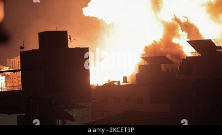 Über den Gebäuden in Gaza-Stadt explodiert ein Feuerball, als israelische Truppen die palästinensische Enklave Anfang des 18. Mai 2021 beschießen. - Israelische Jets hielten eine Flut von Luftangriffen gegen die palästinensische Enklave Gaza aufrecht, als eine Woche der Gewalt, die mehr als 200 Menschen getötet hat, die Staats- und Regierungschefs der Welt dazu drängte, die Mediation zu verstärken. (Foto von Momen Faiz/NurPhoto) Stockfoto