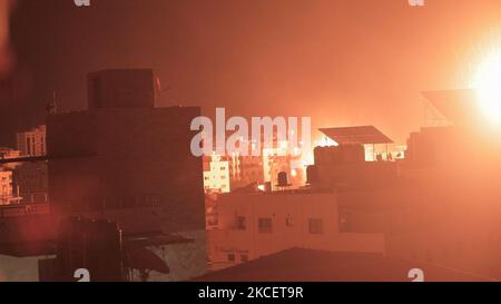 Über den Gebäuden in Gaza-Stadt explodiert ein Feuerball, als israelische Truppen die palästinensische Enklave Anfang des 18. Mai 2021 beschießen. - Israelische Jets hielten eine Flut von Luftangriffen gegen die palästinensische Enklave Gaza aufrecht, als eine Woche der Gewalt, die mehr als 200 Menschen getötet hat, die Staats- und Regierungschefs der Welt dazu drängte, die Mediation zu verstärken. (Foto von Momen Faiz/NurPhoto) Stockfoto