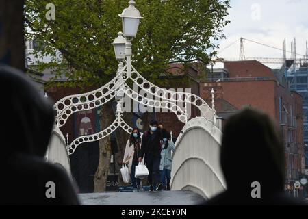 Am Dienstag, den 18. Mai 2021, wandern die Menschen im Zentrum von Dublin bei Regen über die Ha'Penny Bridge. (Foto von Artur Widak/NurPhoto) Stockfoto