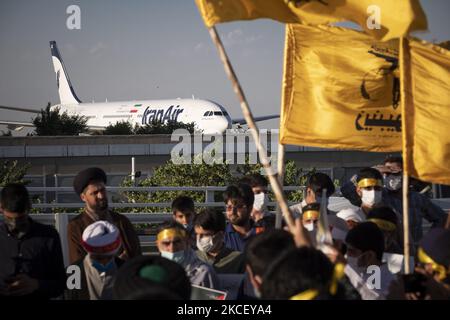 Eine Gruppe iranischer Geistlicher, die während einer symbolischen Versammlung auf dem Internationalen Flughafen Imam Khomeini (IKIA) im Süden von Teheran Flaggen tragen, um als Zeichen ihrer Einheit mit dem palästinensischen Volk nach Gaza zu reisen, um gegen Israel zu kämpfen, Als Airliner für die Airline der Islamischen Republik Iran (Iran Air) wird am 19. Mai 2021 auf einer Start- und Landebahn gesehen. (Foto von Morteza Nikoubazl/NurPhoto) Stockfoto