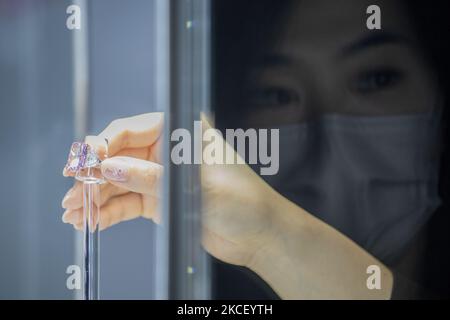 Eine Frau hält den Sakura-Diamanten während der Vorschau bei Christie's in Hongkong, China, 20. Mai 2021. Der 15,81 Karat Fancy Vivid Purple Pink Internally Flawless Type lla Diamond Ring wird am 23. Mai 2021 in Hongkong für geschätzte 25 bis 38 Millionen US-Dollar versteigert. (Foto von Vernon Yuen/NurPhoto) Stockfoto